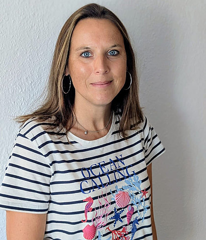 Porträt einer Frau vor weißer Wand mit OCEAN CALLING T-Shirt